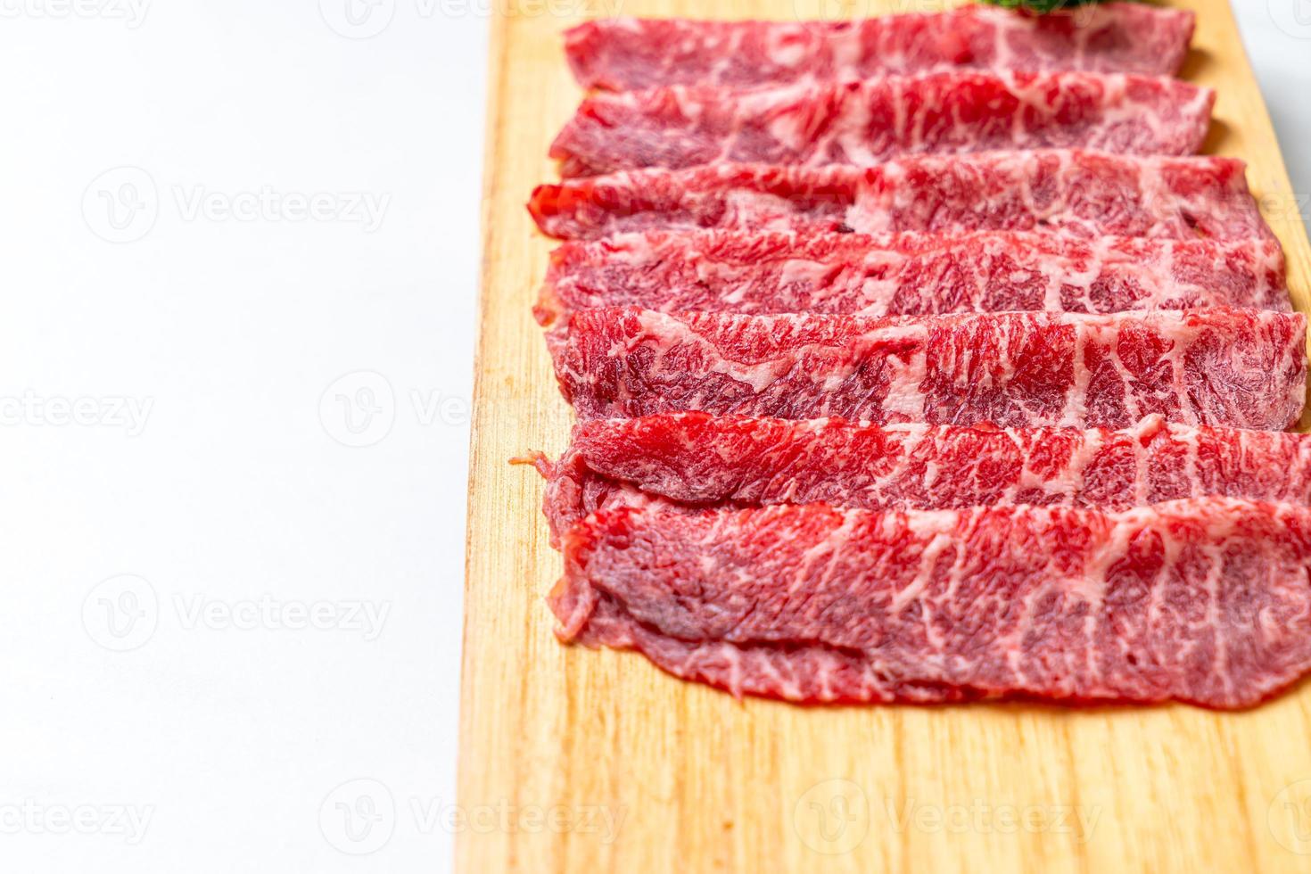 Carne fresca cruda en rodajas con textura de mármol servida para sukiyaki y shabu o yakiniku foto