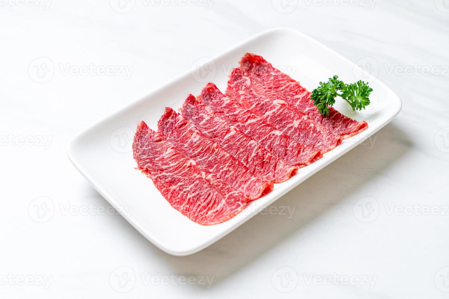 Fresh beef raw sliced with marbled texture served for Sukiyaki and Shabu or Yakiniku photo