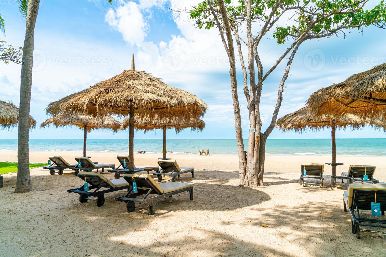 Beach chairs and umbrellas with ocean sea beach background photo