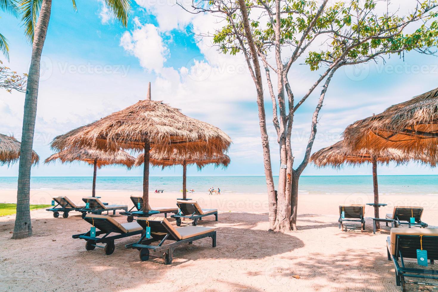 Beach chairs and umbrellas with ocean sea beach background photo