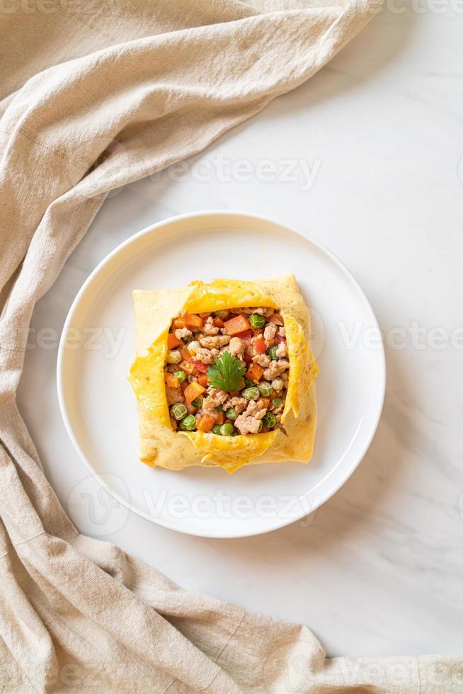 Egg wrap or stuffed egg with minced pork, carrot, tomato, and green peas photo