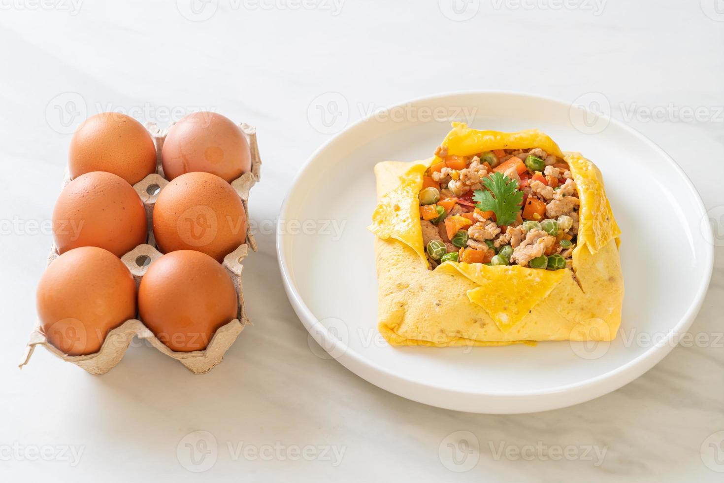 Egg wrap or stuffed egg with minced pork, carrot, tomato, and green peas photo