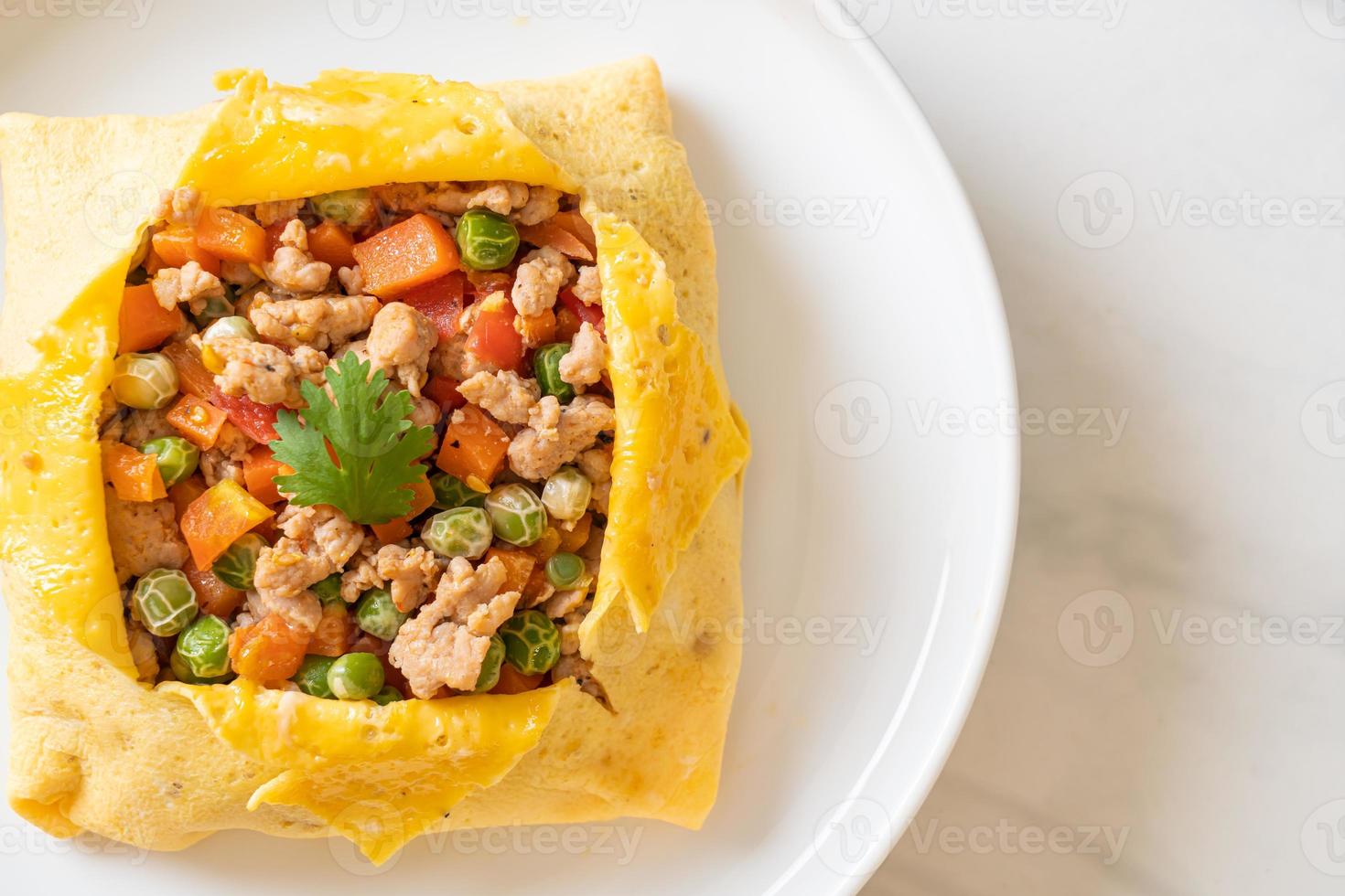 Egg wrap or stuffed egg with minced pork, carrot, tomato, and green peas photo