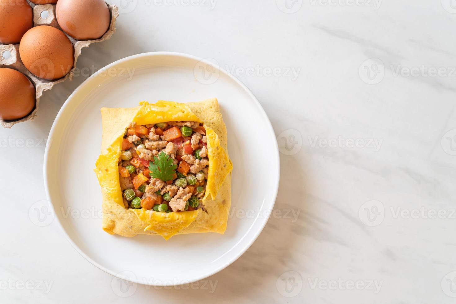 Egg wrap or stuffed egg with minced pork, carrot, tomato, and green peas photo