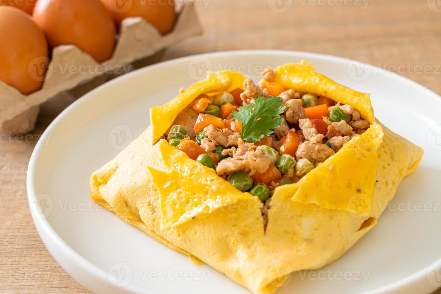 Egg wrap or stuffed egg with minced pork, carrot, tomato, and green peas photo