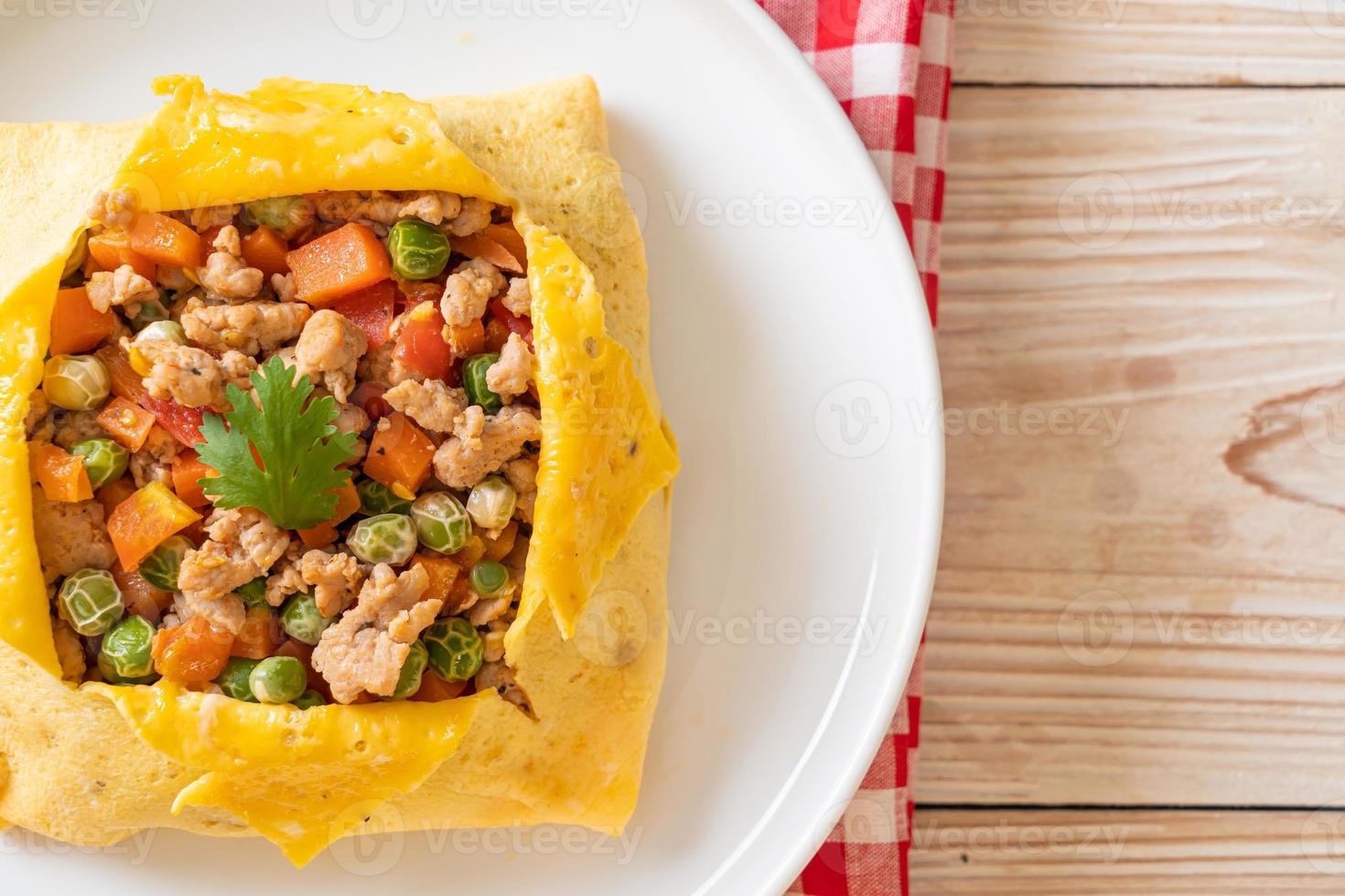 Egg wrap or stuffed egg with minced pork, carrot, tomato, and green peas photo