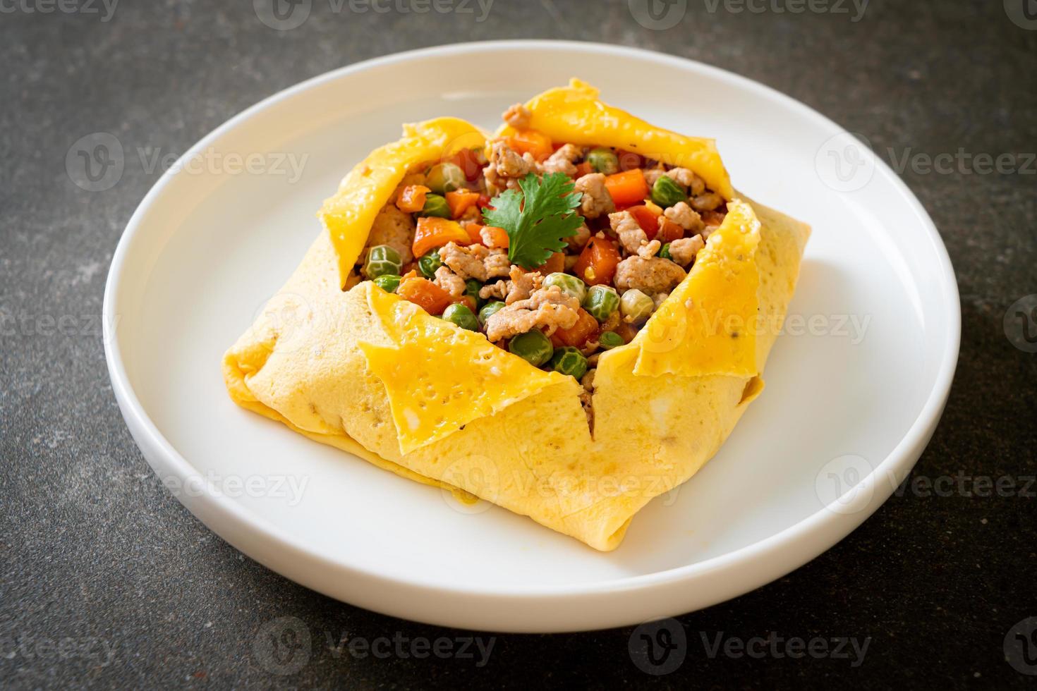 Egg wrap or stuffed egg with minced pork, carrot, tomato, and green peas photo