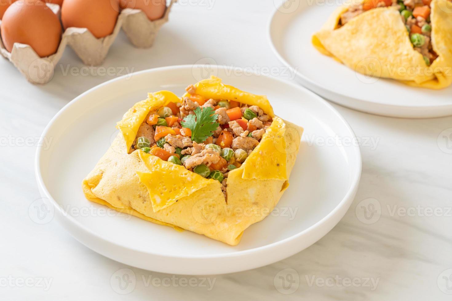 Egg wrap or stuffed egg with minced pork, carrot, tomato, and green peas photo