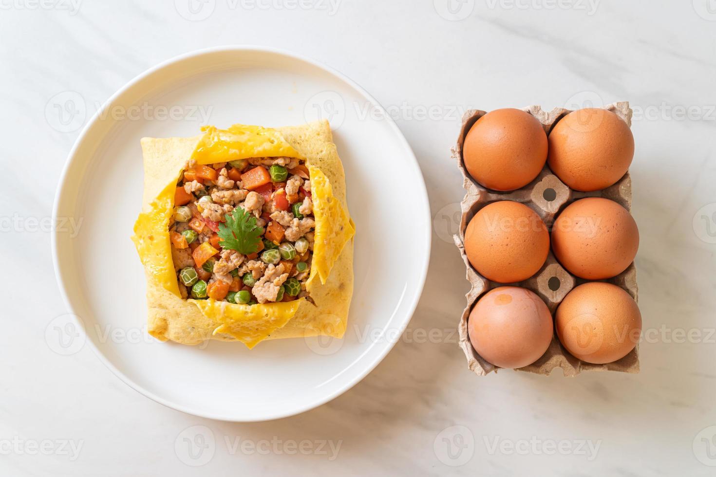 Egg wrap or stuffed egg with minced pork, carrot, tomato, and green peas photo