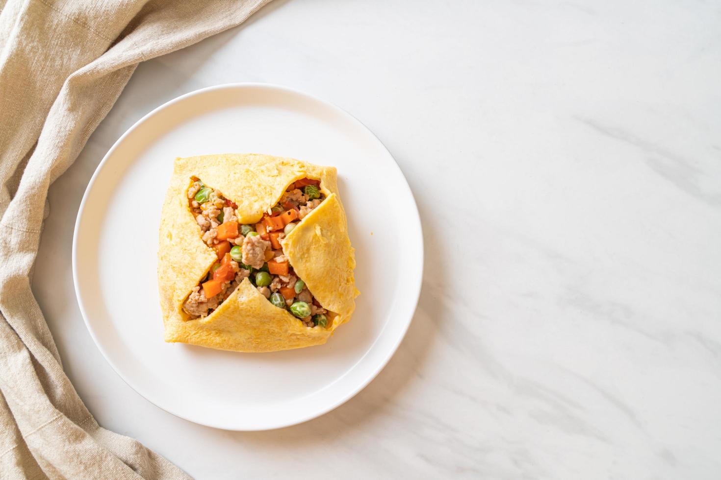 Egg wrap or stuffed egg with minced pork, carrot, tomato, and green peas photo