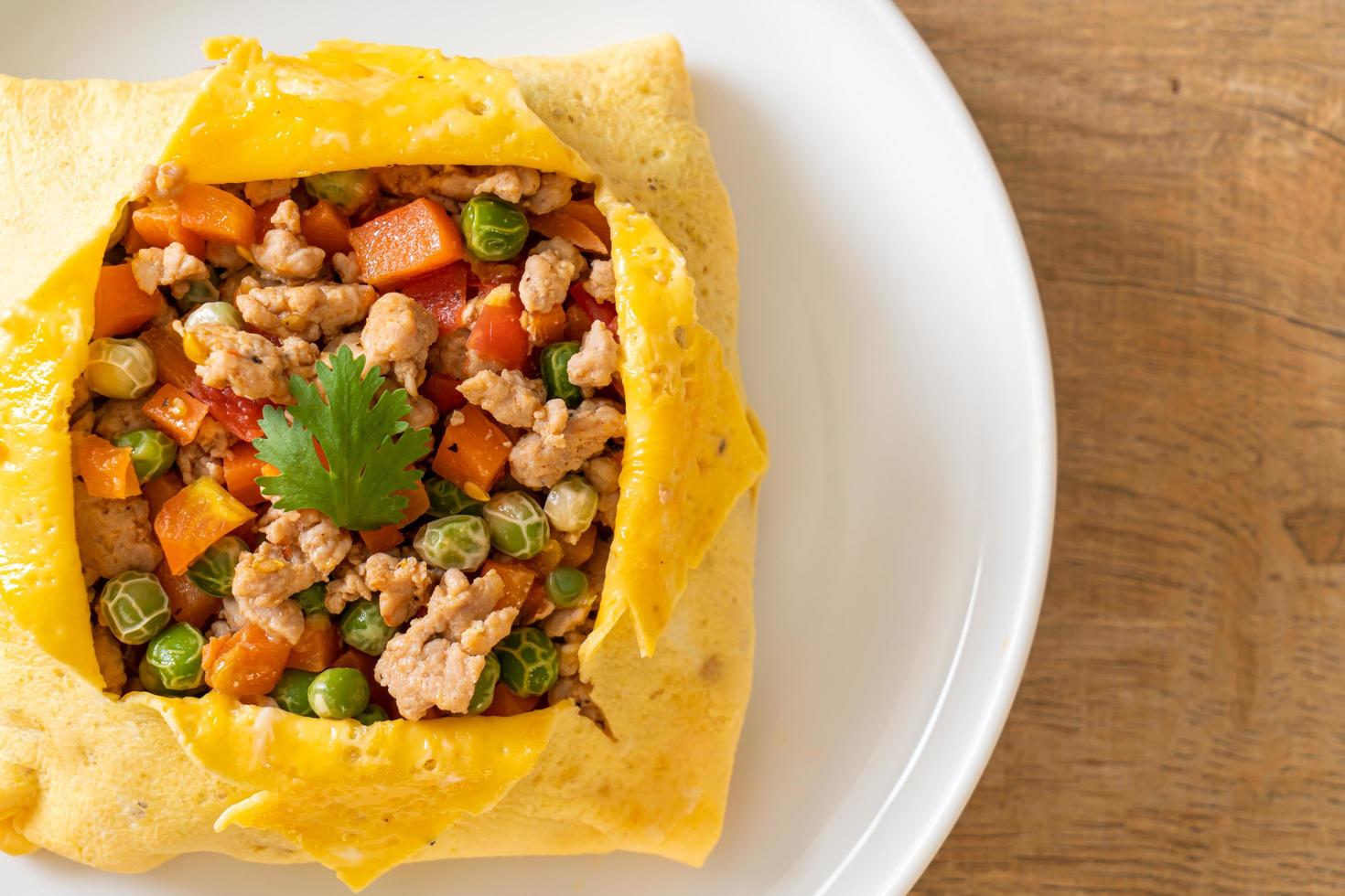 envoltura de huevo o huevo relleno con carne de cerdo picada, zanahoria, tomate y guisantes foto