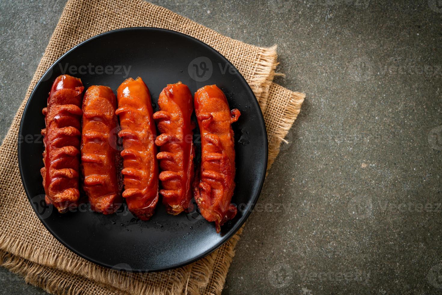 Brocheta de salchicha frita sobre placa negra foto