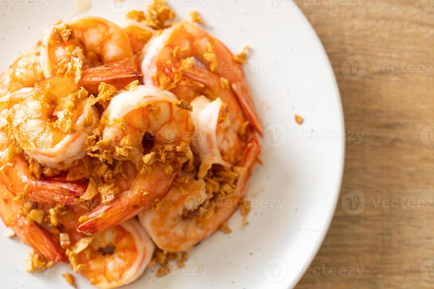 Camarones fritos o gambas con ajo en un plato blanco - estilo marisco foto