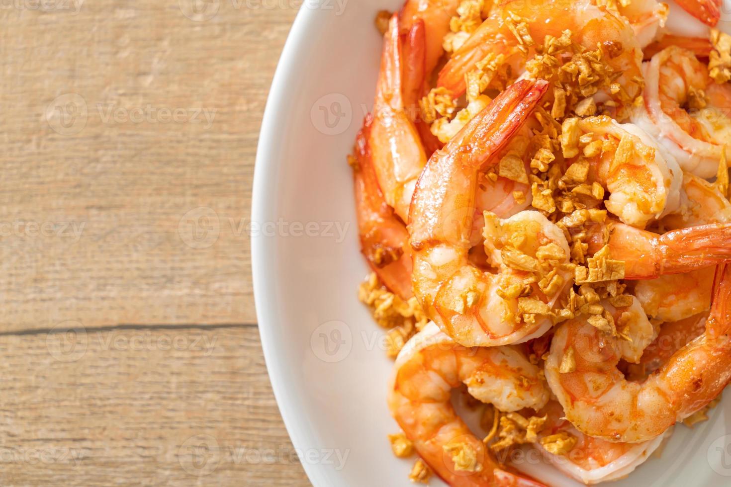 Fried shrimps or prawns with garlic on white plate - seafood style photo