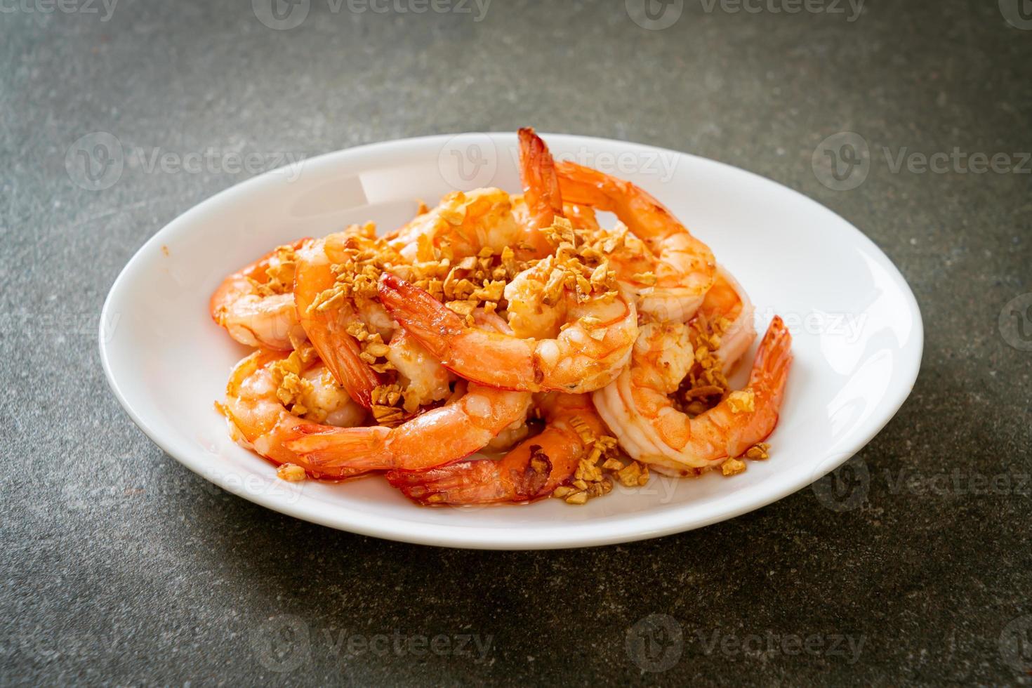 Camarones fritos o gambas con ajo en un plato blanco - estilo marisco foto