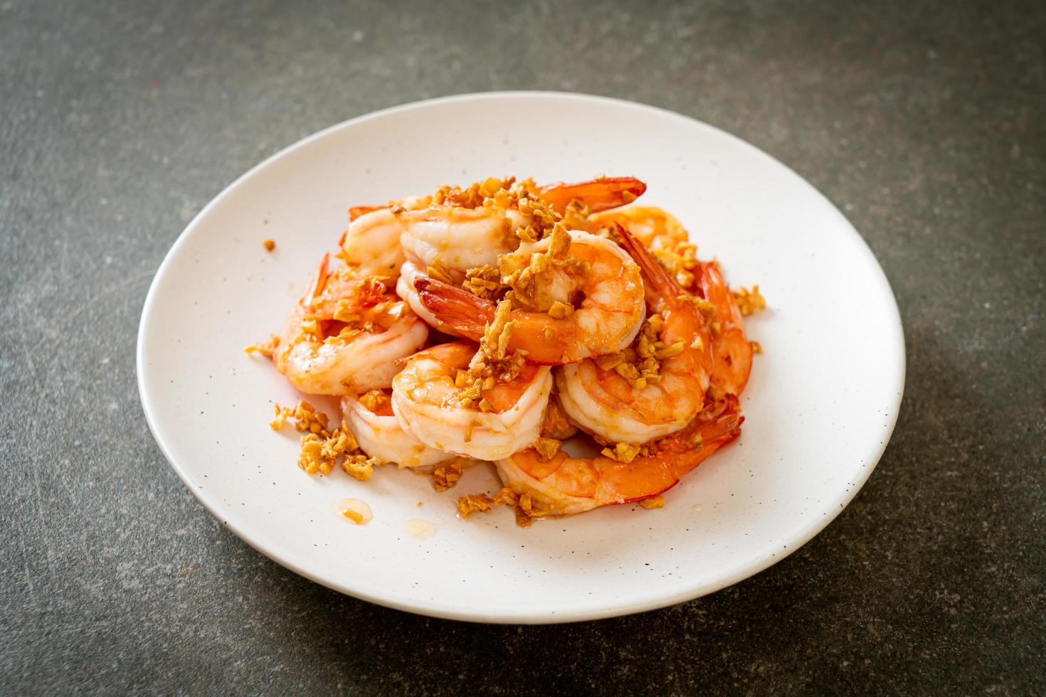 Fried shrimps or prawns with garlic on white plate - seafood style photo