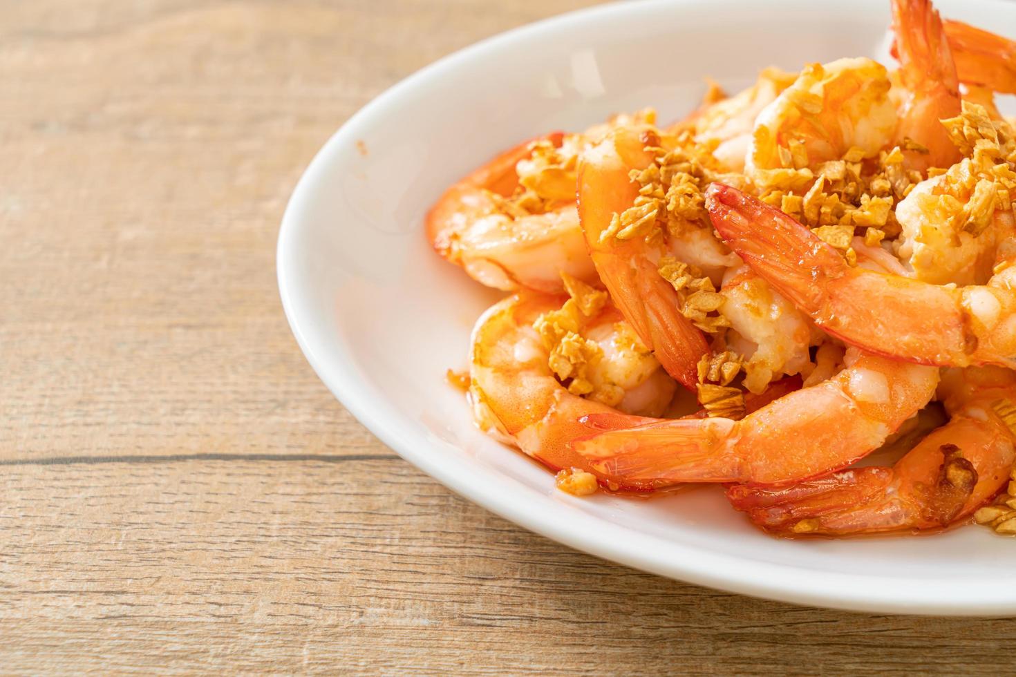 Fried shrimps or prawns with garlic on white plate - seafood style photo