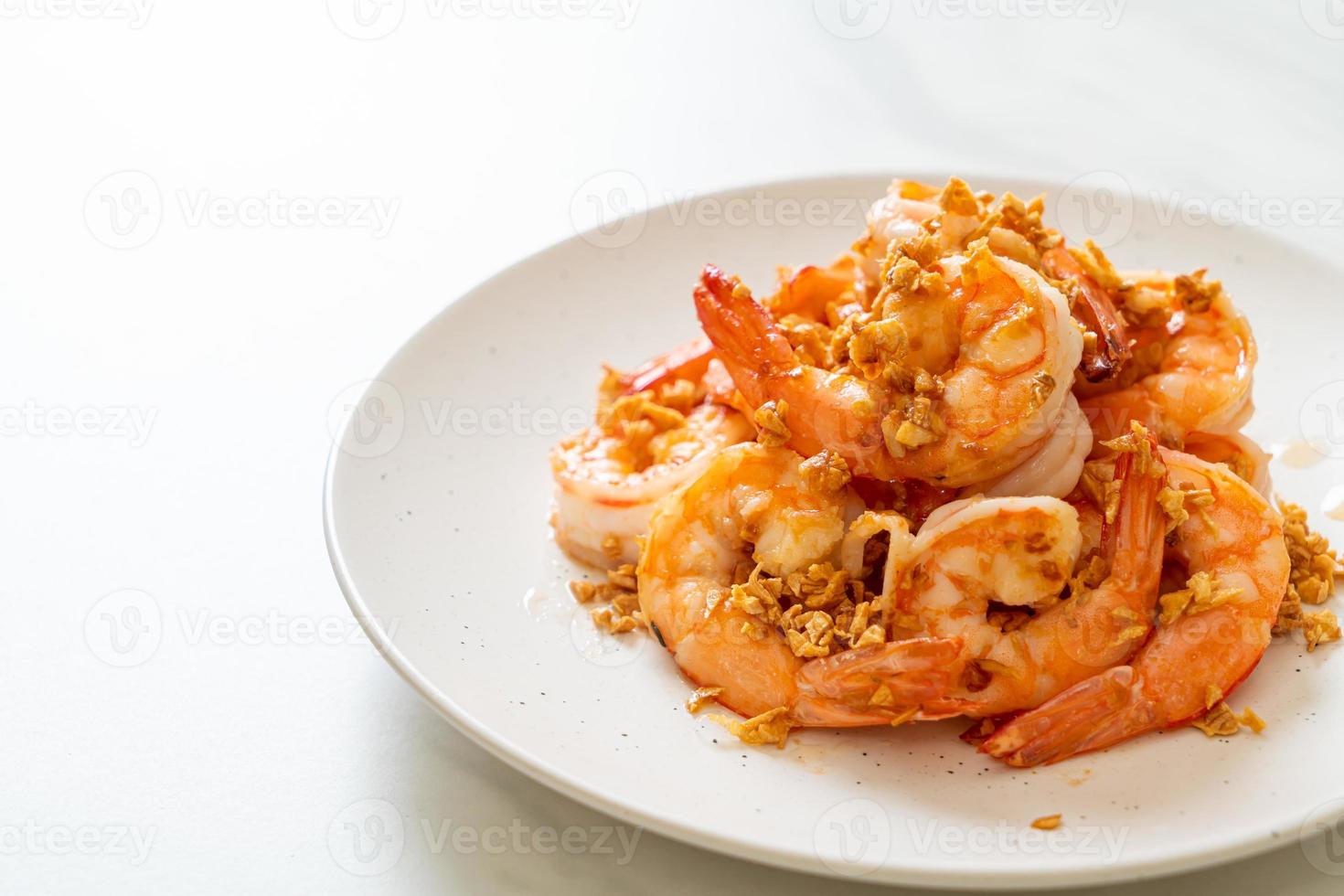 Camarones fritos o gambas con ajo en un plato blanco - estilo marisco foto