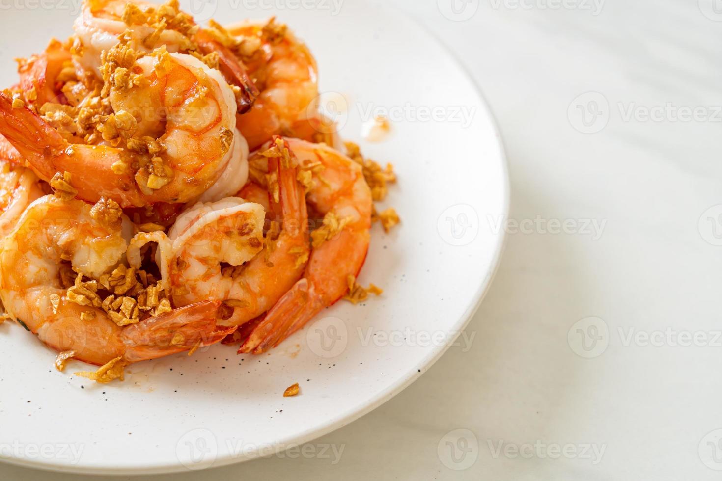 Camarones fritos o gambas con ajo en un plato blanco - estilo marisco foto