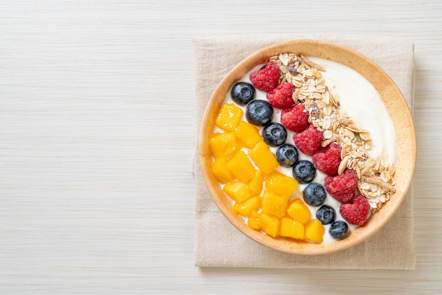 Homemade yogurt bowl with raspberry, blueberry, mango and granola - healthy food style photo