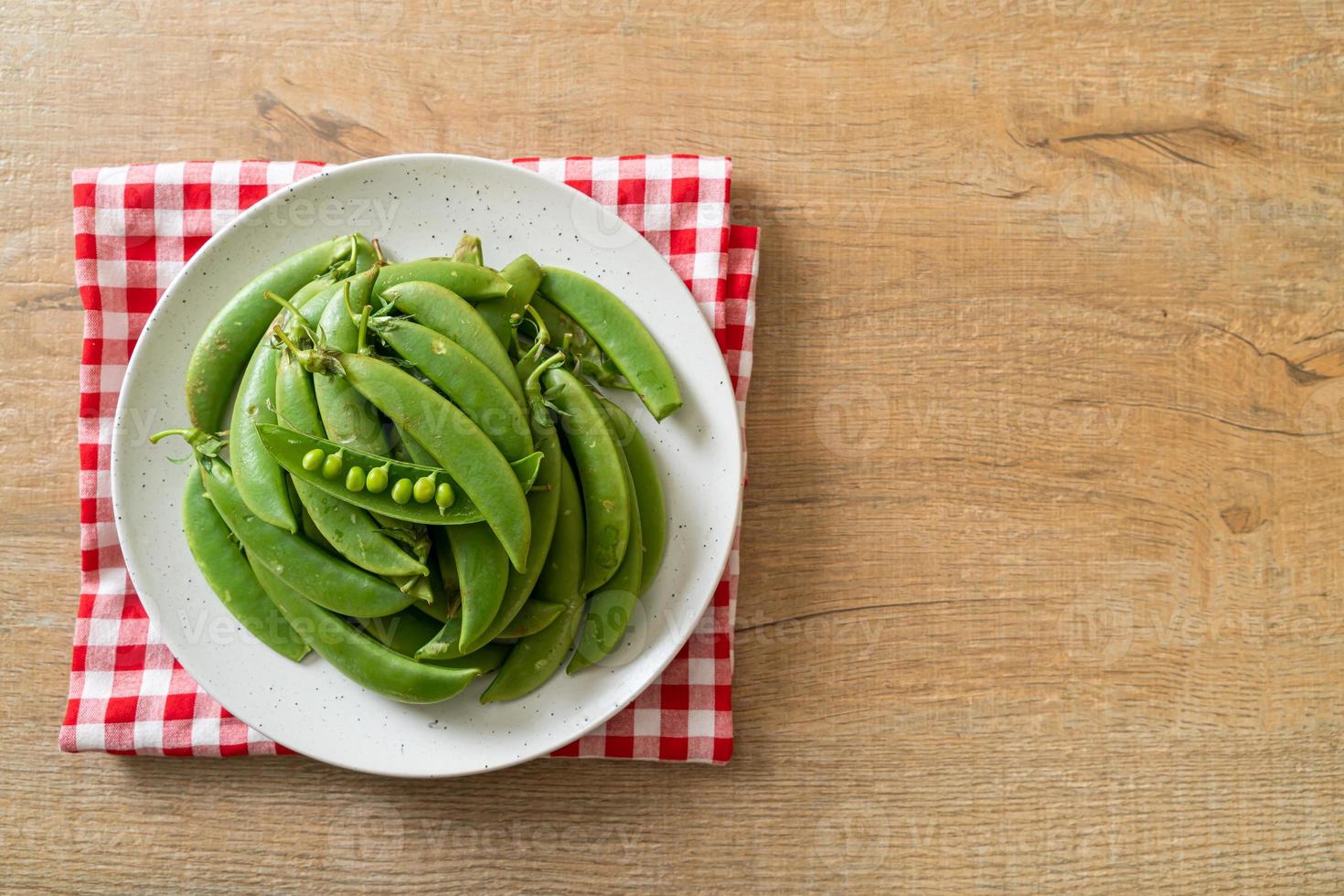 Fresh sweet green peas on white plate photo