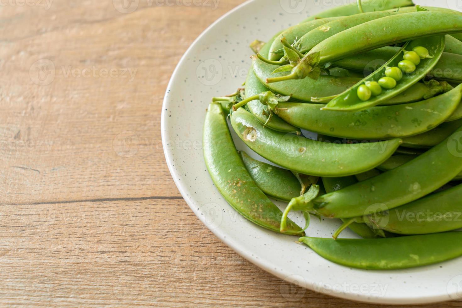 Fresh sweet green peas on white plate photo