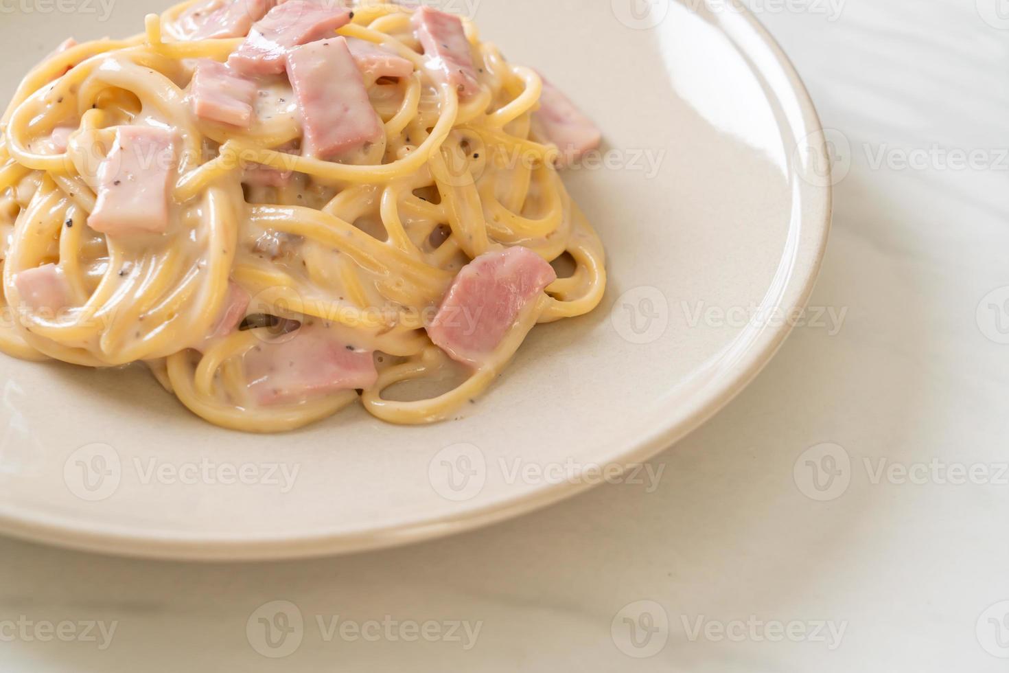 Espaguetis caseros con salsa de crema blanca con jamón - estilo de comida italiana foto