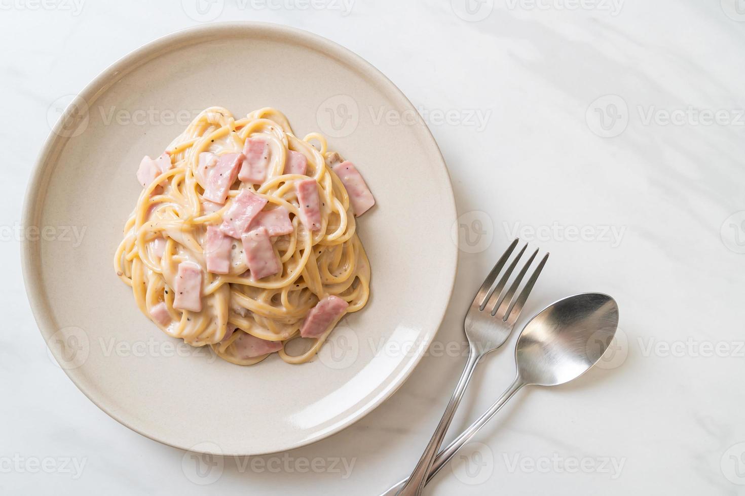 Espaguetis caseros con salsa de crema blanca con jamón - estilo de comida italiana foto