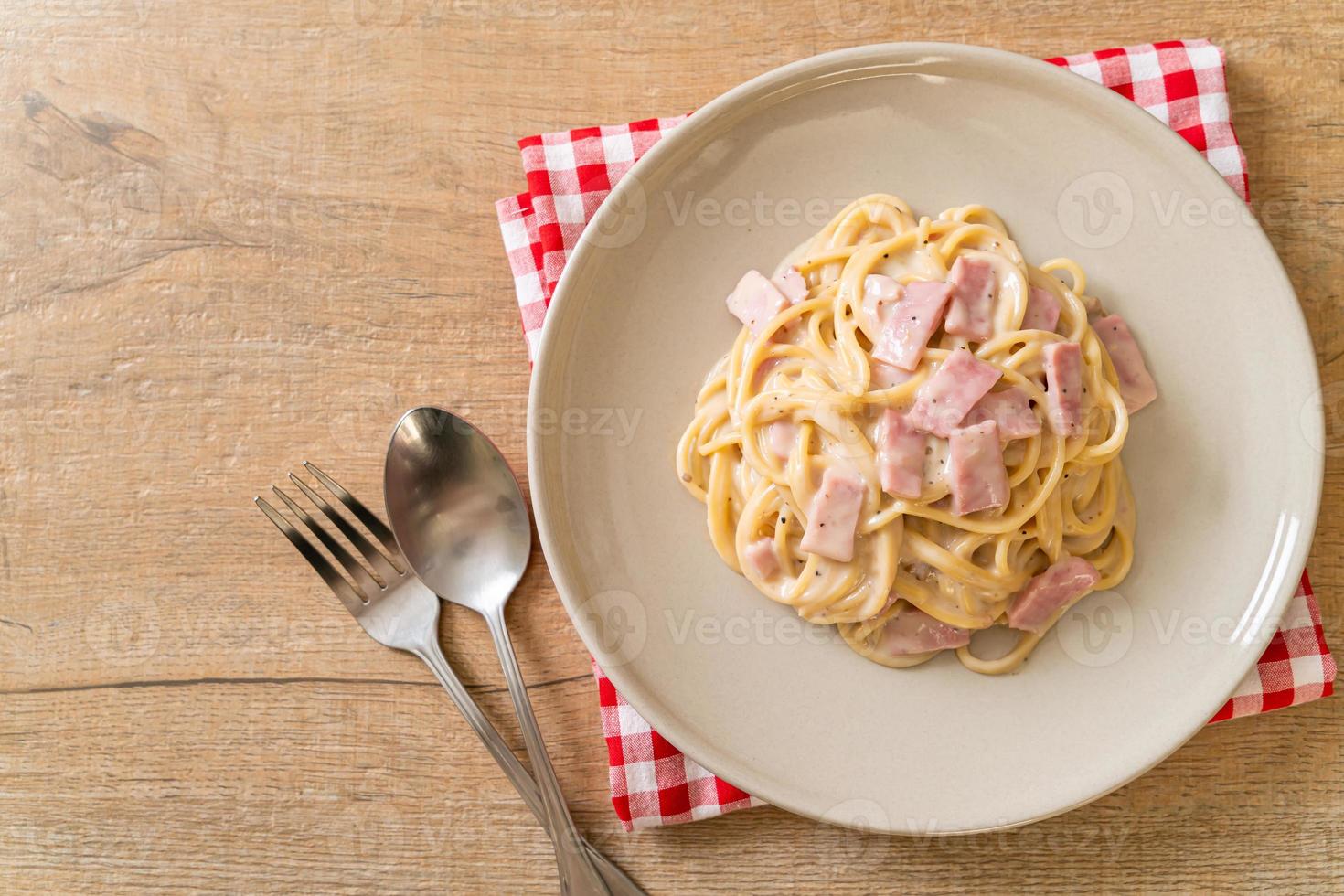 Espaguetis caseros con salsa de crema blanca con jamón - estilo de comida italiana foto