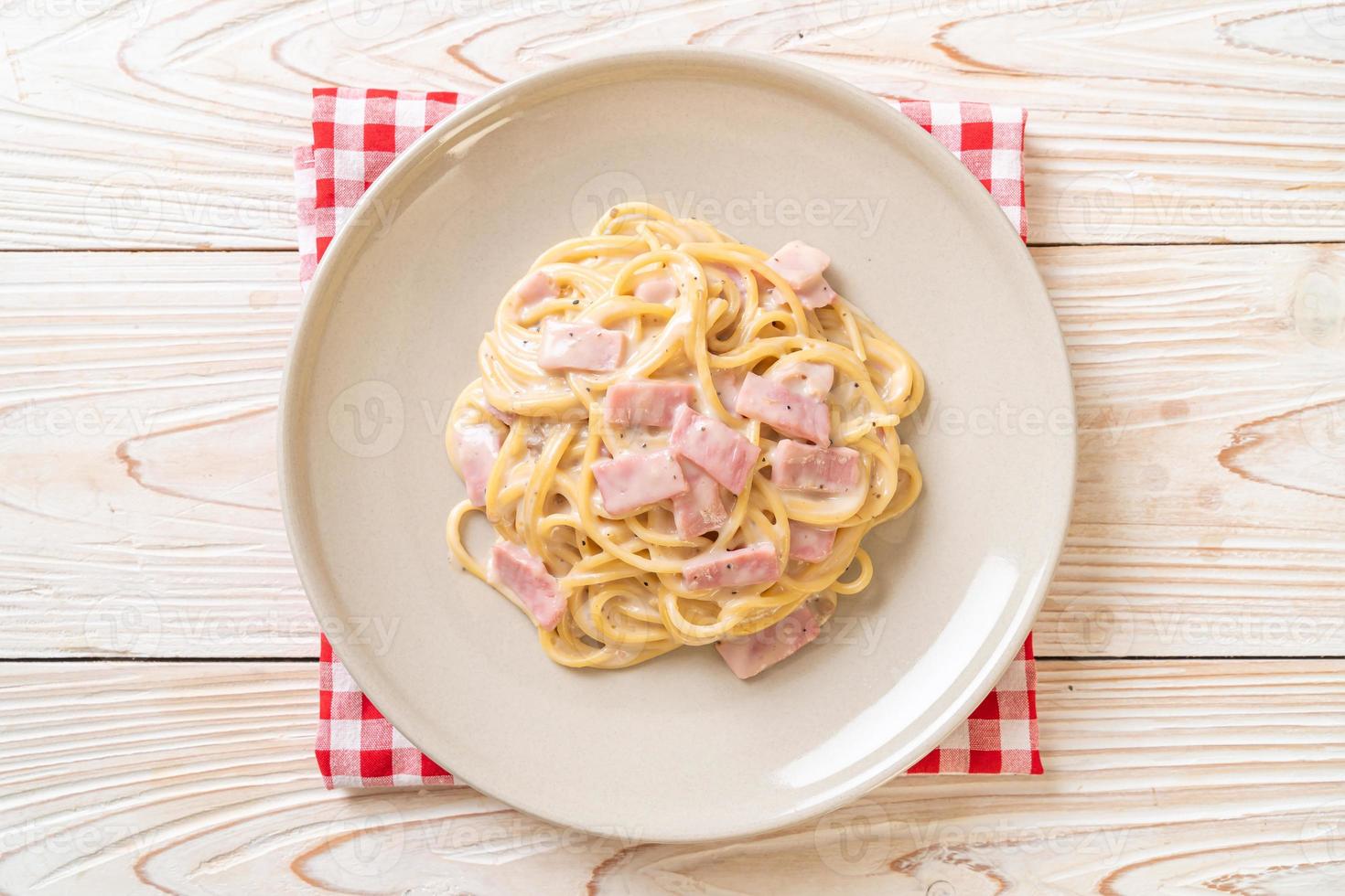 Espaguetis caseros con salsa de crema blanca con jamón - estilo de comida italiana foto