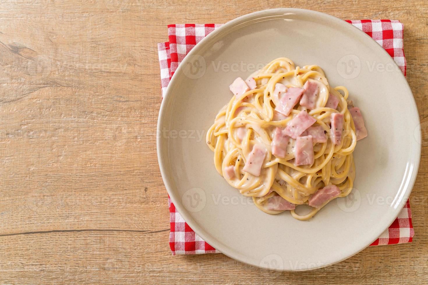 Espaguetis caseros con salsa de crema blanca con jamón - estilo de comida italiana foto