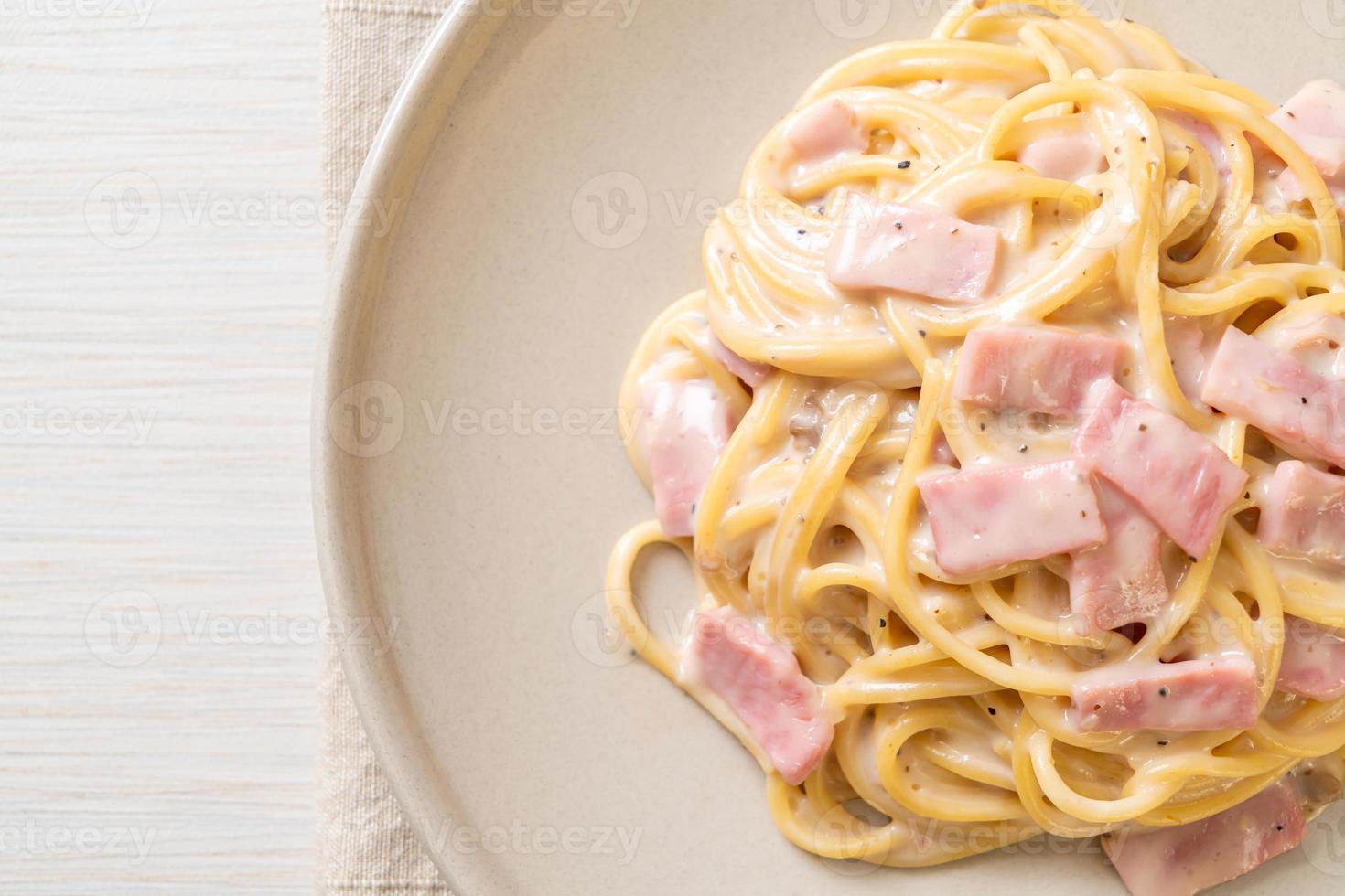 Espaguetis caseros con salsa de crema blanca con jamón - estilo de comida italiana foto