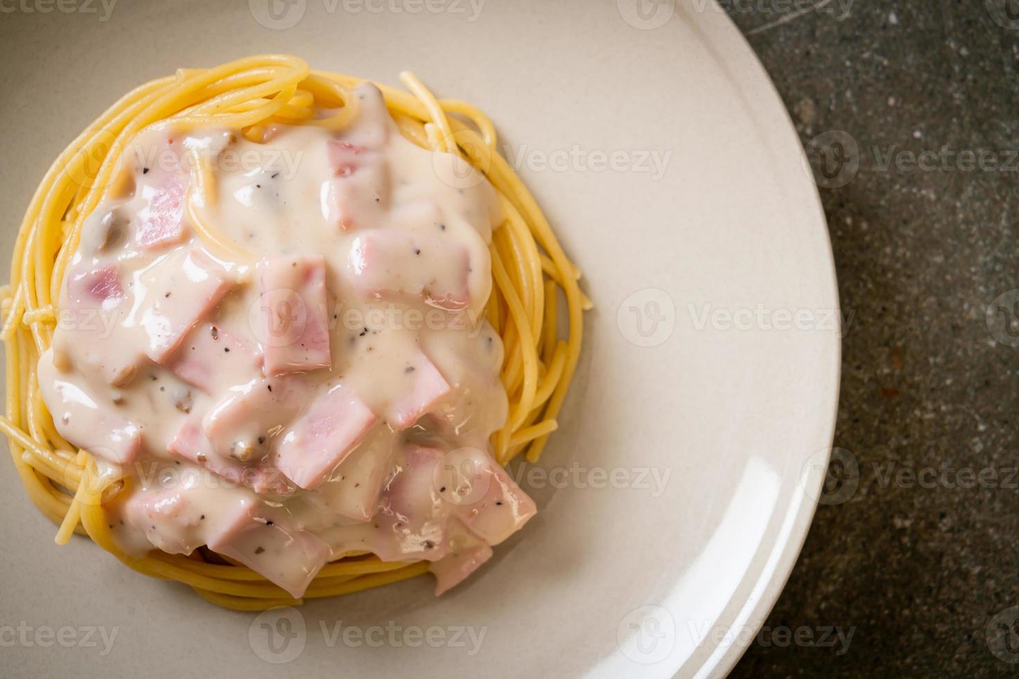 Espaguetis caseros con salsa de crema blanca con jamón - estilo de comida italiana foto