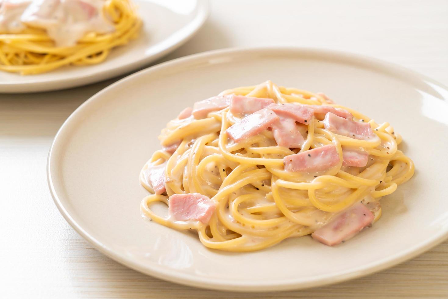 Espaguetis caseros con salsa de crema blanca con jamón - estilo de comida italiana foto