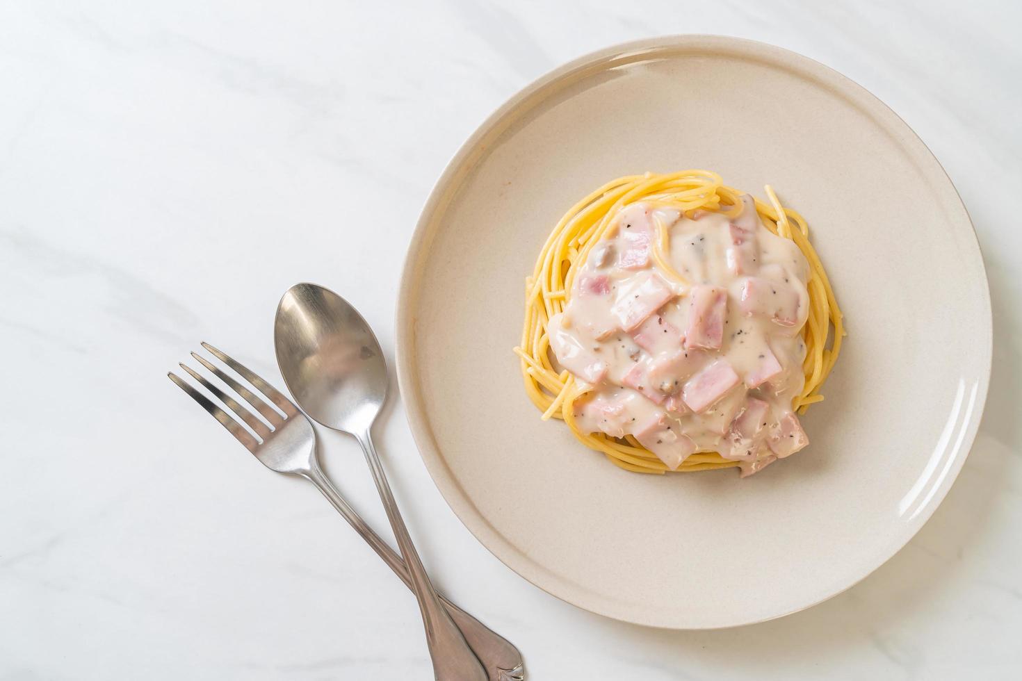 Espaguetis caseros con salsa de crema blanca con jamón - estilo de comida italiana foto