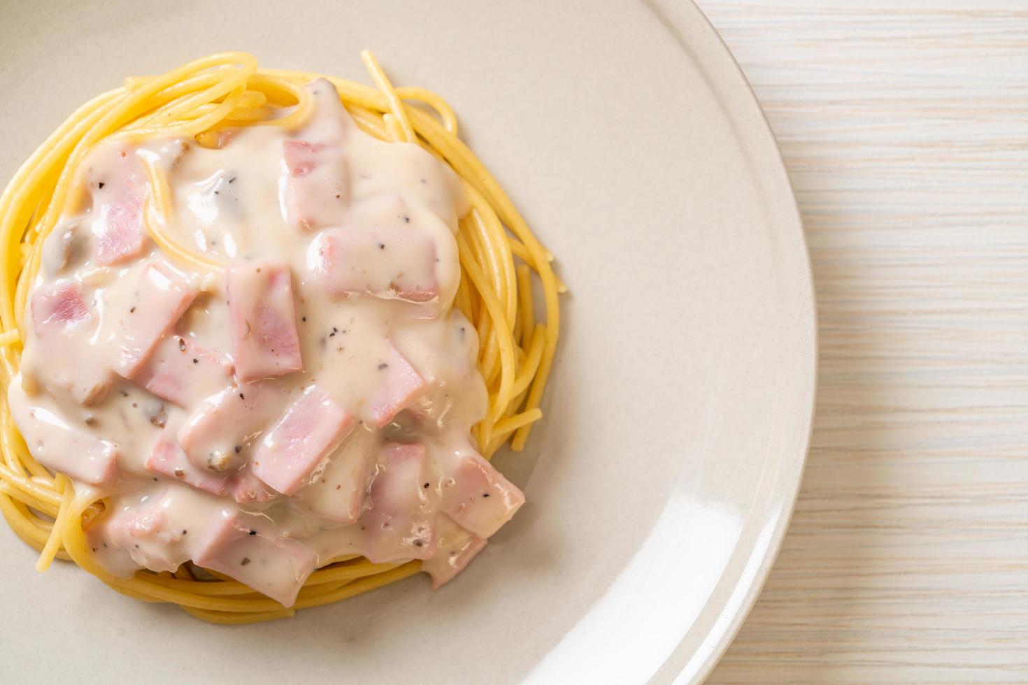 Espaguetis caseros con salsa de crema blanca con jamón - estilo de comida italiana foto