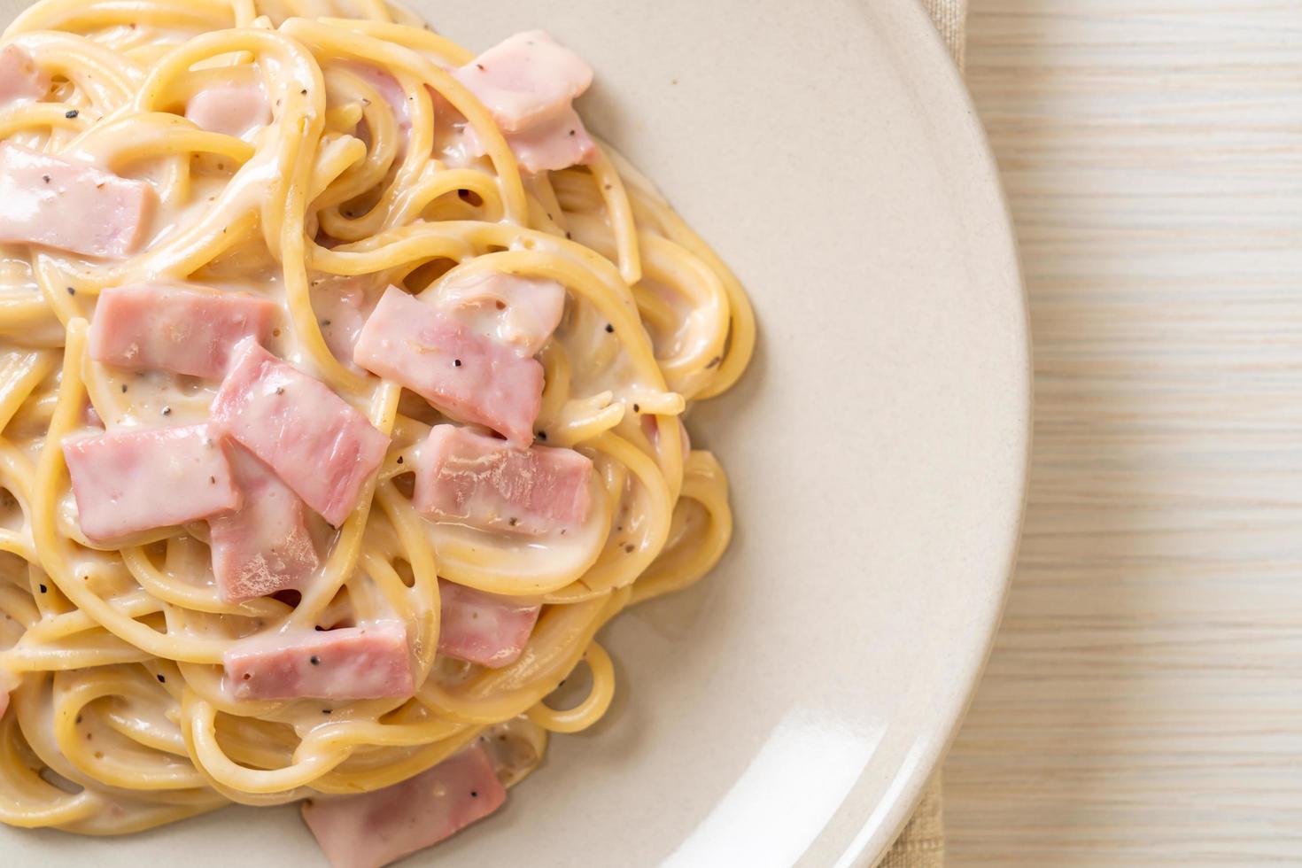 Espaguetis caseros con salsa de crema blanca con jamón - estilo de comida italiana foto