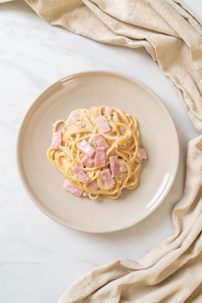 Espaguetis caseros con salsa de crema blanca con jamón - estilo de comida italiana foto