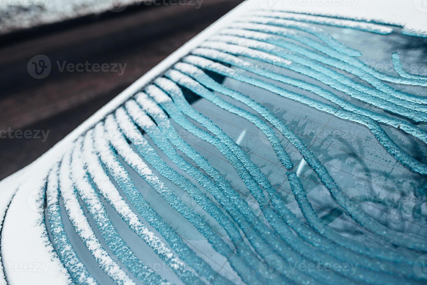 Ice melts on the rear window of the car - electric window heating with contact strips photo