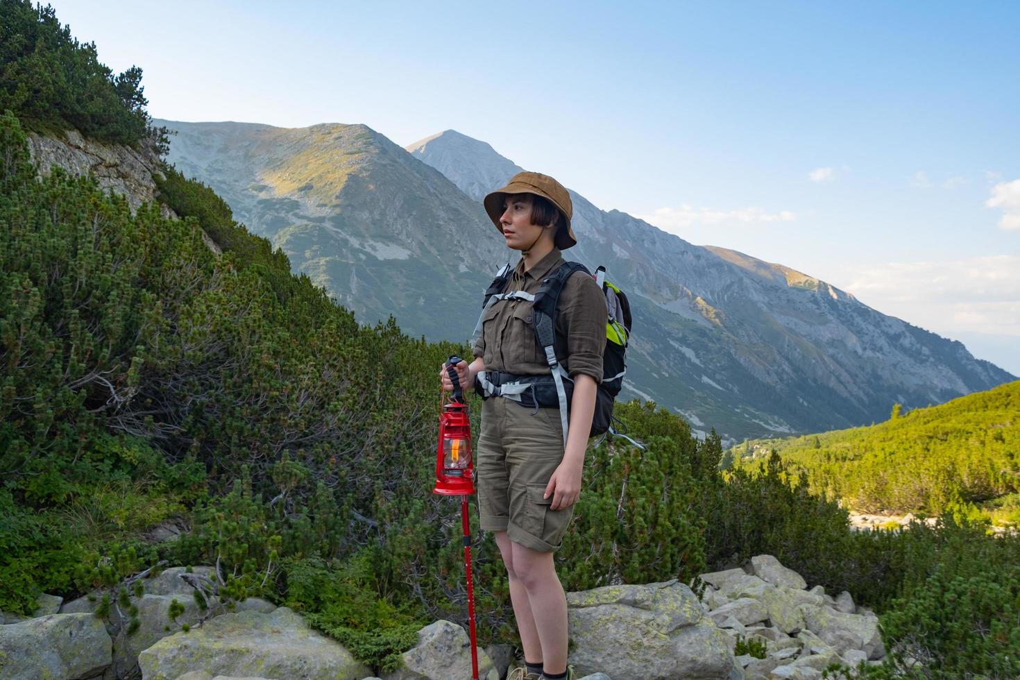 Young woman traveler with backpack in the mountains photo