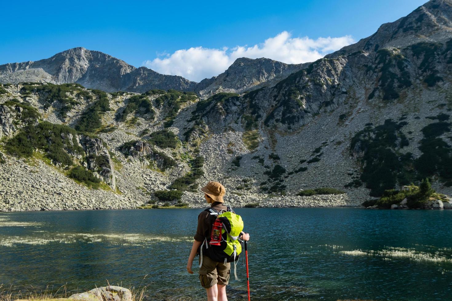 Young woman traveler with backpack in the mountains photo