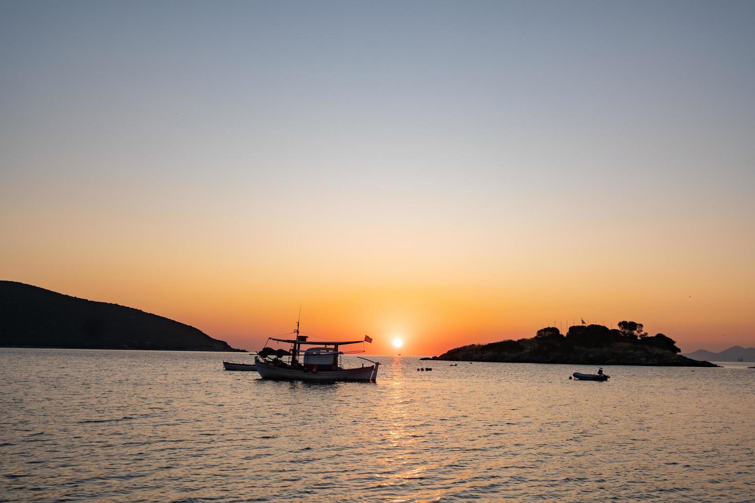 Landscape with fishing boat in the sea with beautiful sunrise on background photo