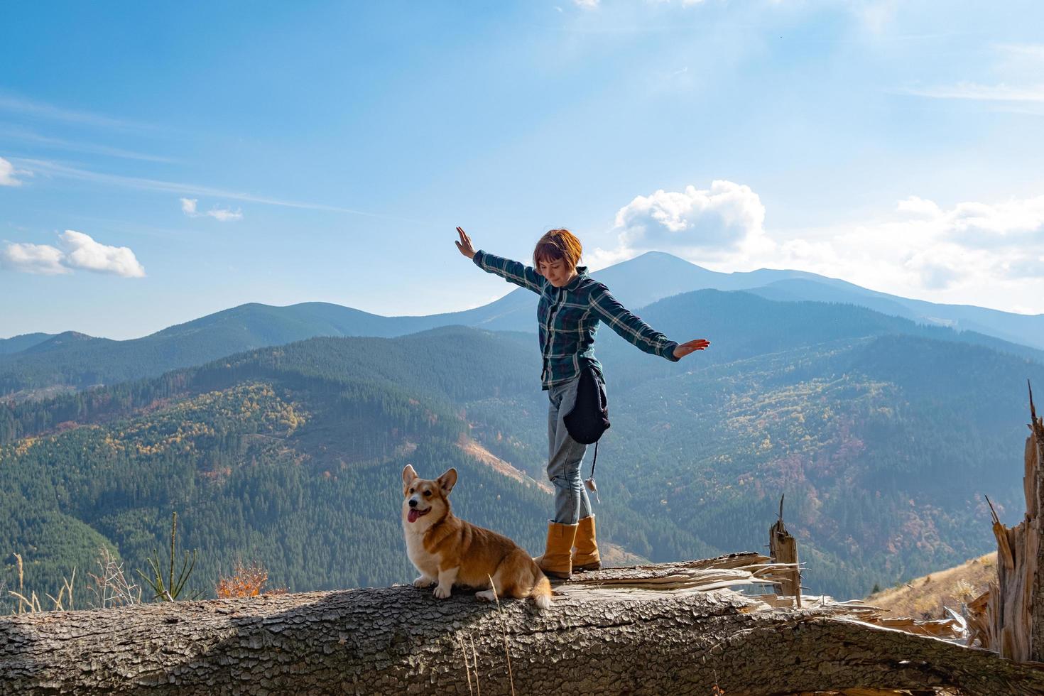 Viajero joven con perro corgi en las montañas foto