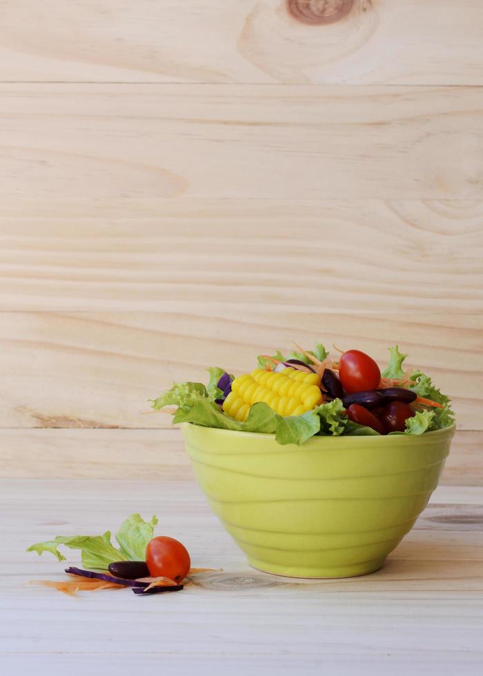 Ensalada de verduras frescas para alimentos saludables sobre fondos de madera verticales foto