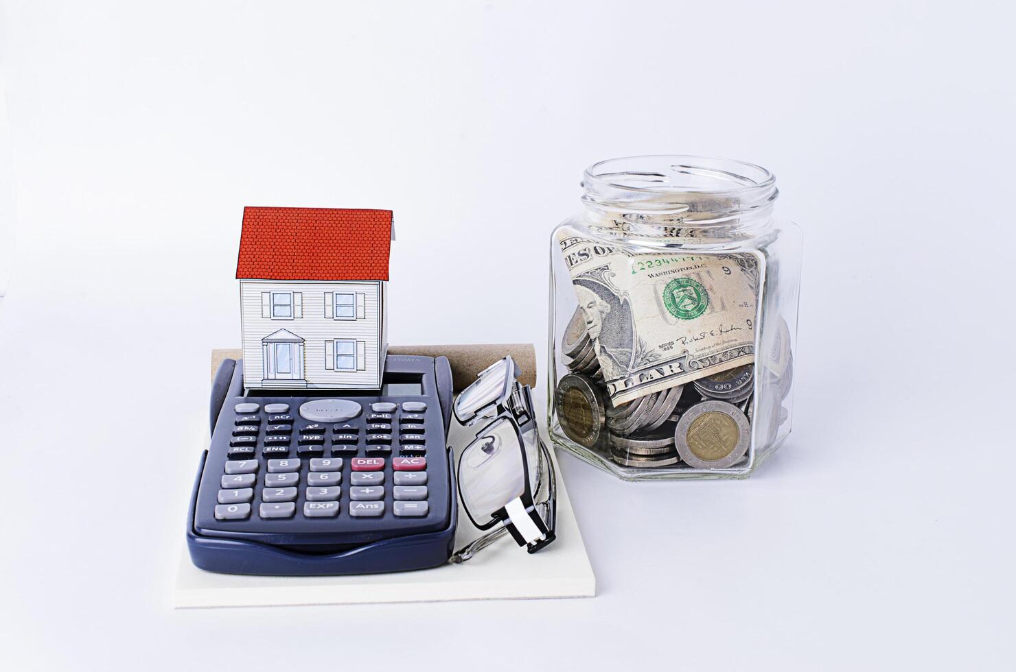 Paper house with calculator and glasses and bottles saving money photo