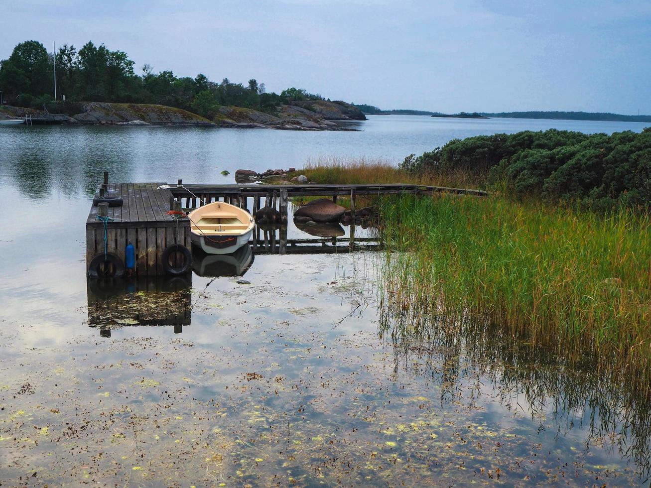 Rowing boat moored at a small jetty in the Baltic Sea near Mariehamn Aland Finland photo