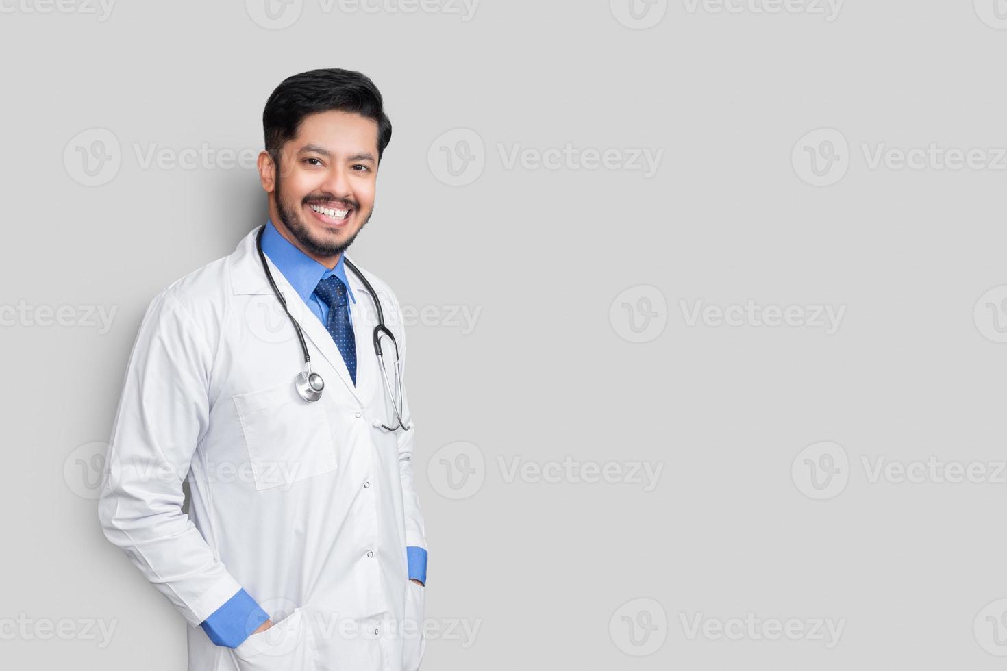 Retrato de médico masculino con estetoscopio y brazos en capa aislado sobre fondo blanco. concepto de seguro médico. foto