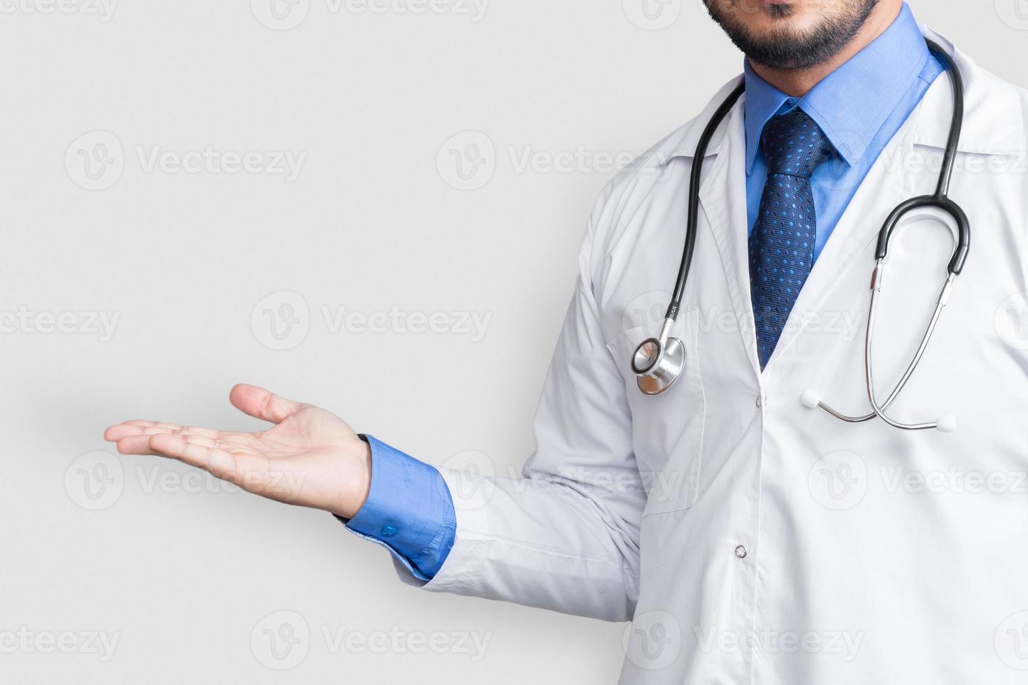 Doctor holding stethoscope in neck while presenting  isolated on white background with copy space photo