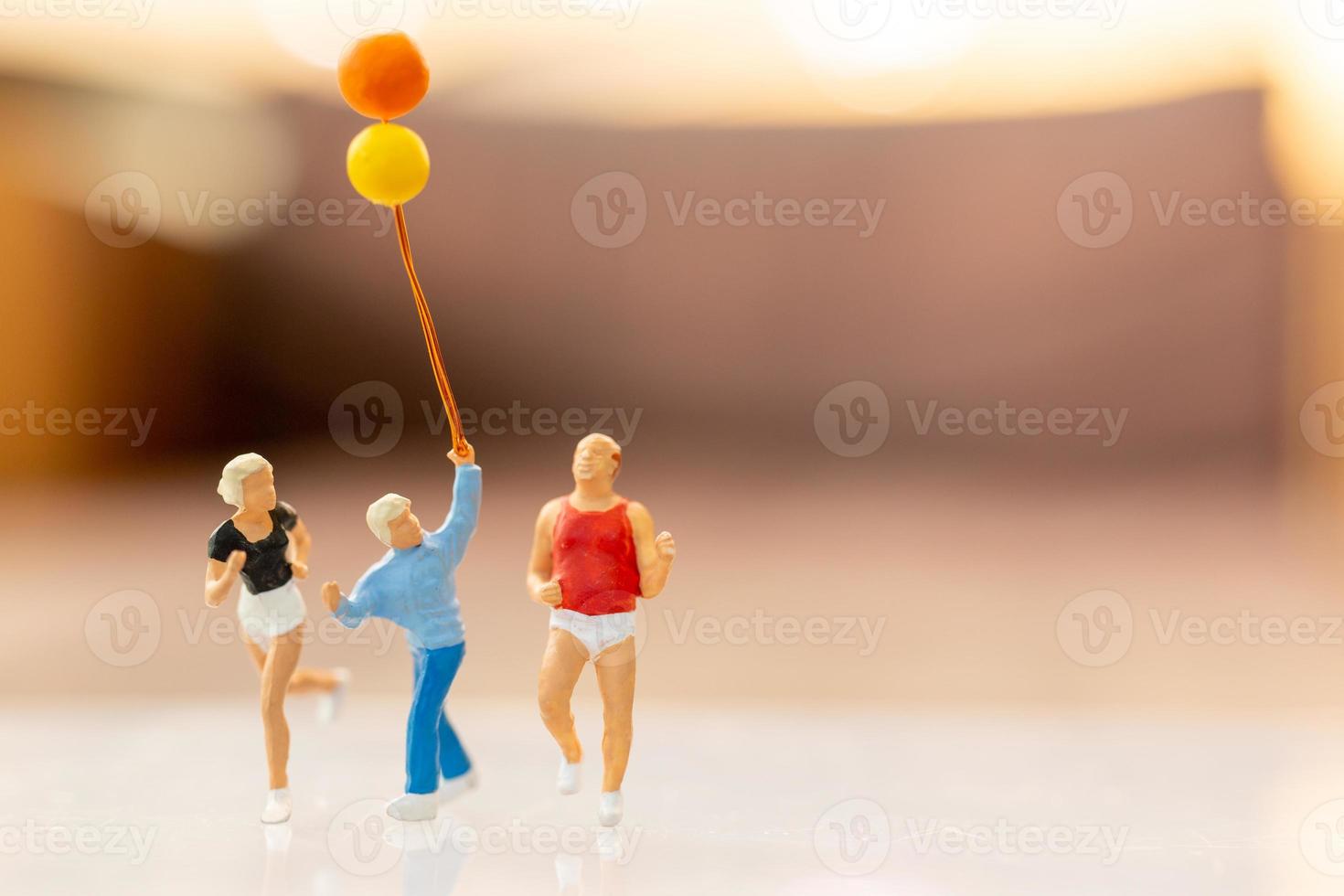 Miniature people happy family running and playing with balloon photo