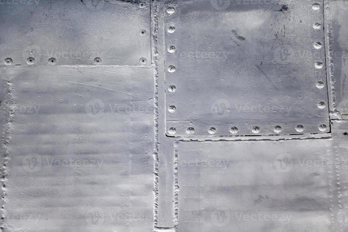 Aircraft skin close up. Rivets on gray metal. photo